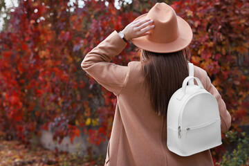 Poster - Young woman with stylish white backpack in autumn park, back view