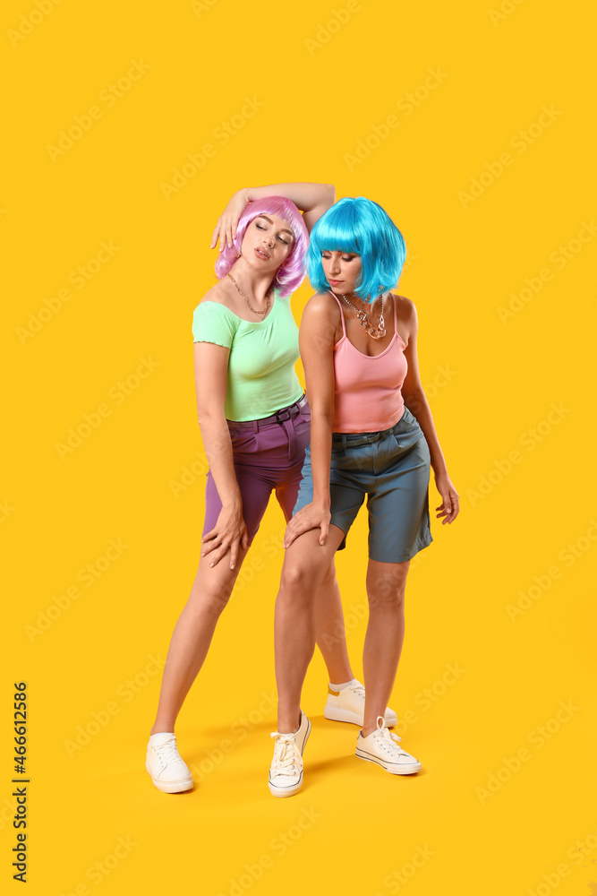 Fashionable young women on color background