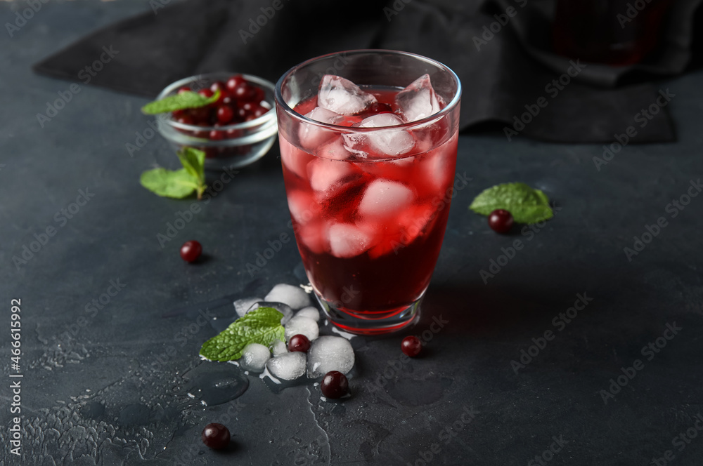 Glass with healthy cranberry juice on dark background