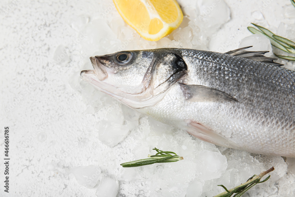 Fresh uncooked sea bass fish and lemon on light background, closeup
