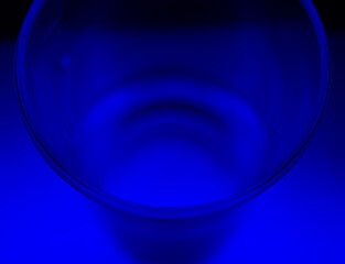 Canvas Print - Closeup shot of a glass cup on a blue background