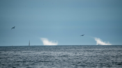 Canvas Print - Aircrafts in the sky leaving a white cloud trail in the distance