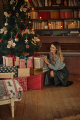 Wall Mural - Happy young woman holding christmas present box