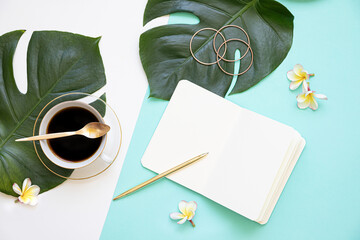 Wall Mural - Tropical workspace concept. Notepad and tropical palm leaves. Mockup presentation workplace.