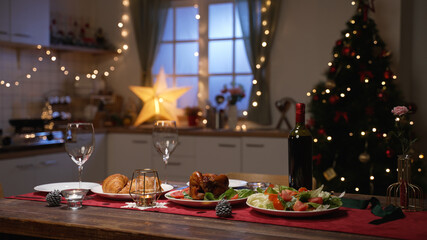 selective focus of romantic new year’s eve dinner table setting for two with wine in a modern festive home interior on blurred background