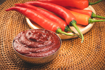 Wall Mural - Korean pepper paste and red pepper in wooden plate, Gochujang Korean traditionl Chili paste on a wooden table background.