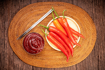 Wall Mural - Korean pepper paste and red pepper in wooden plate, Gochujang Korean traditionl Chili paste on a wooden table background.