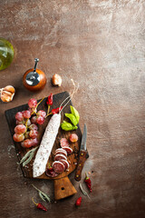 Wall Mural - Board with tasty slices of salami and fresh grapes