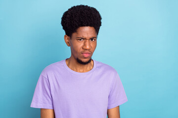 Wall Mural - Photo of sad millennial brunet guy wear violet t-shirt isolated on blue color background