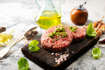 Wall Mural - Raw cutlet of minced meat on a wooden cutting board.