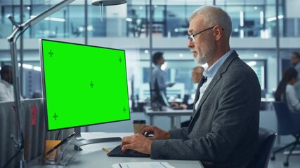 Poster - Diverse Modern Office: Senior Caucasian IT Technician Using Desktop Computer with Green Chroma Key Screen. Engineer Administrator Work on e-Commerce Development, Project Marketing, Big Data Analysis