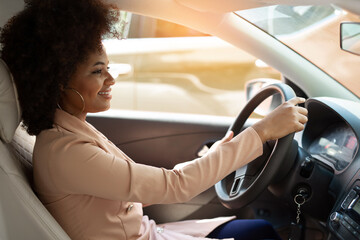 Wall Mural - african successful woman driving driving car in suit 