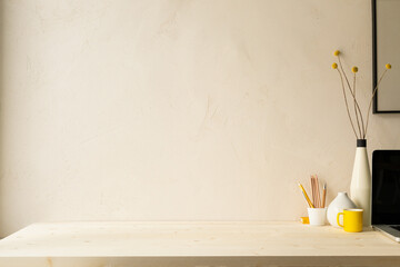 Wall Mural - Workspace with computer, flower, desk empty space on a beige cement wall background.