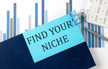 Poster - FIND YOUR NICHE on sticky note on notebook on the chart background