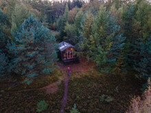 Wooden Hut In An Autumn Forest In The Netherlands, Cabin Off Grid , Wooden Cabin Circled By Colorful Yellow And Red Fall Trees. Couple Mid Age European Man And Asian Woman In A Cabin In The Woods
