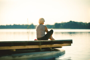 Senior woman sitting by the lake