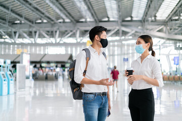 Wall Mural - New normal,travel bubble and social distancing concept.Traveler man and woman wearing face mask and waiting to board at terminal airport for protection coronavirus(covid-19) during virus pandemic