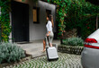 Businesswoman with suitcase returning home from business trip.