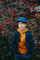 Close up portrait of a boy near chokeberries bush