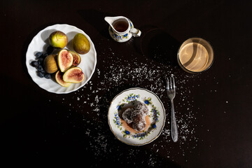 Canvas Print - Delicious dessert on a plate with syrup and figs on a black table