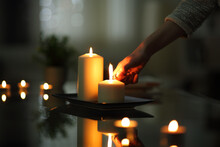 Close Up Of Woman Hand Lighting Candle In The Night