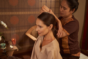 Wall Mural - Dreamy calm female client during assisted stretching procedure