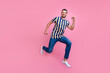 © deagreez - Full size profile photo of funky young brunet guy run wear t-shirt jeans sneakers isolated on pink background