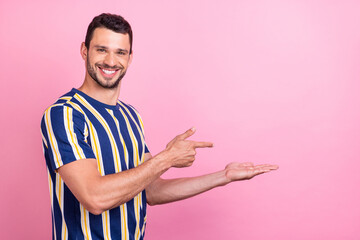 Photo portrait man smiling showing copyspace on palm isolated pastel pink color background