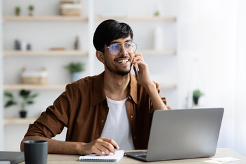 Happy successful middle eastern man talking on phone