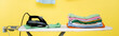 © LIGHTFIELD STUDIOS - ironing board with stack of clean laundry and electric iron on yellow background, banner.