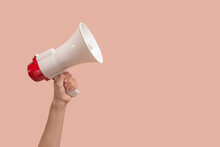 Megaphone In Woman Hands On A Pink Background.