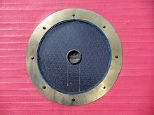 Porthole Round Ventilation Window On Red Wall