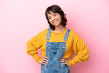 Young Woman With Overalls Isolated Background Posing With Arms At Hip And Smiling