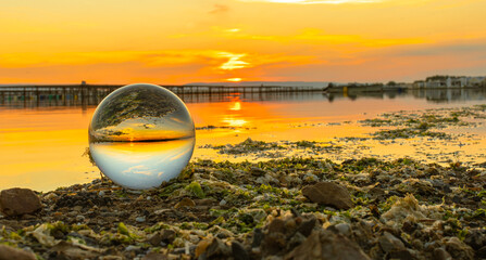 Wall Mural - Boule de cristal avec lumière du coucher de soleil sur un étang de Camargue, France.	