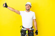 © luismolinero - Young rock- climber man isolated on yellow background giving a thumbs up gesture
