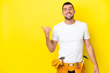 Young Electrician Caucasian Man Isolated On Yellow Background Pointing To The Side To Present A Product
