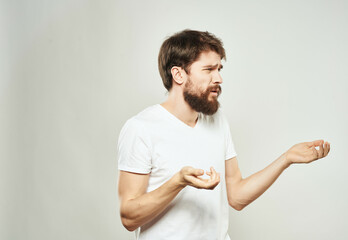 Wall Mural - emotional man in a white t-shirt irritated facial expression close-up