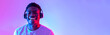 © Prostock-studio - Handsome young black man wearing headphones, listening to music with closed eyes in neon light, banner design
