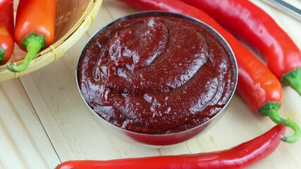 Wall Mural - Korean pepper paste and red pepper in wooden plate, Gochujang Korean traditionl Chili paste on a wooden table background. 4K