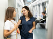 © JackF - Two girlfriends enjoying friendly conversation while traveling on subway train..
