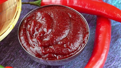 Wall Mural - Korean pepper paste and red pepper on blue wooden plate, Gochujang Korean traditional Chili paste on a wooden table background. 4K