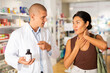 © JackF - Pharmacist offering medicine for sore throat to patient at pharmacy