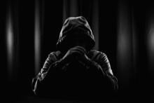 Hackers Wear Hoods To Cover Their Faces. Hacking To Steal Important Information. Use A Computer To Release Malware Viruses Ransom And Harass Organizations. He Sitting In The Dark Room With Neon Light