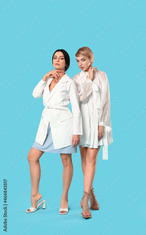 Fashionable young women on color background