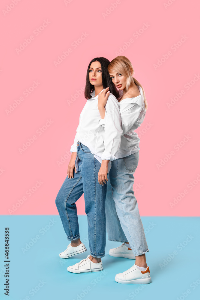 Fashionable young women on color background