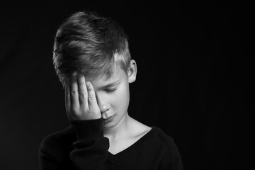 Canvas Print - Upset little boy on black background