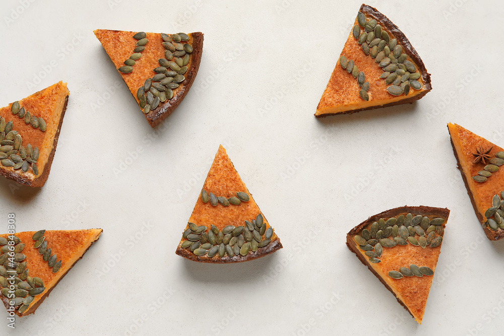 Pieces of delicious pumpkin pie on light background
