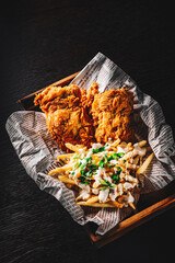 Wall Mural - fried crispy chicken with french fries on rustic wooden table dark background