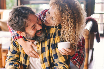 Wall Mural - Man and woman at home smile and enjoy love relationship and friendship together. Cheerful adult people. Female with blonde curly hair and man with beard have fun and leisure time