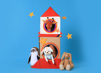 Wall Mural - Cardboard rocket and different toys on light blue background